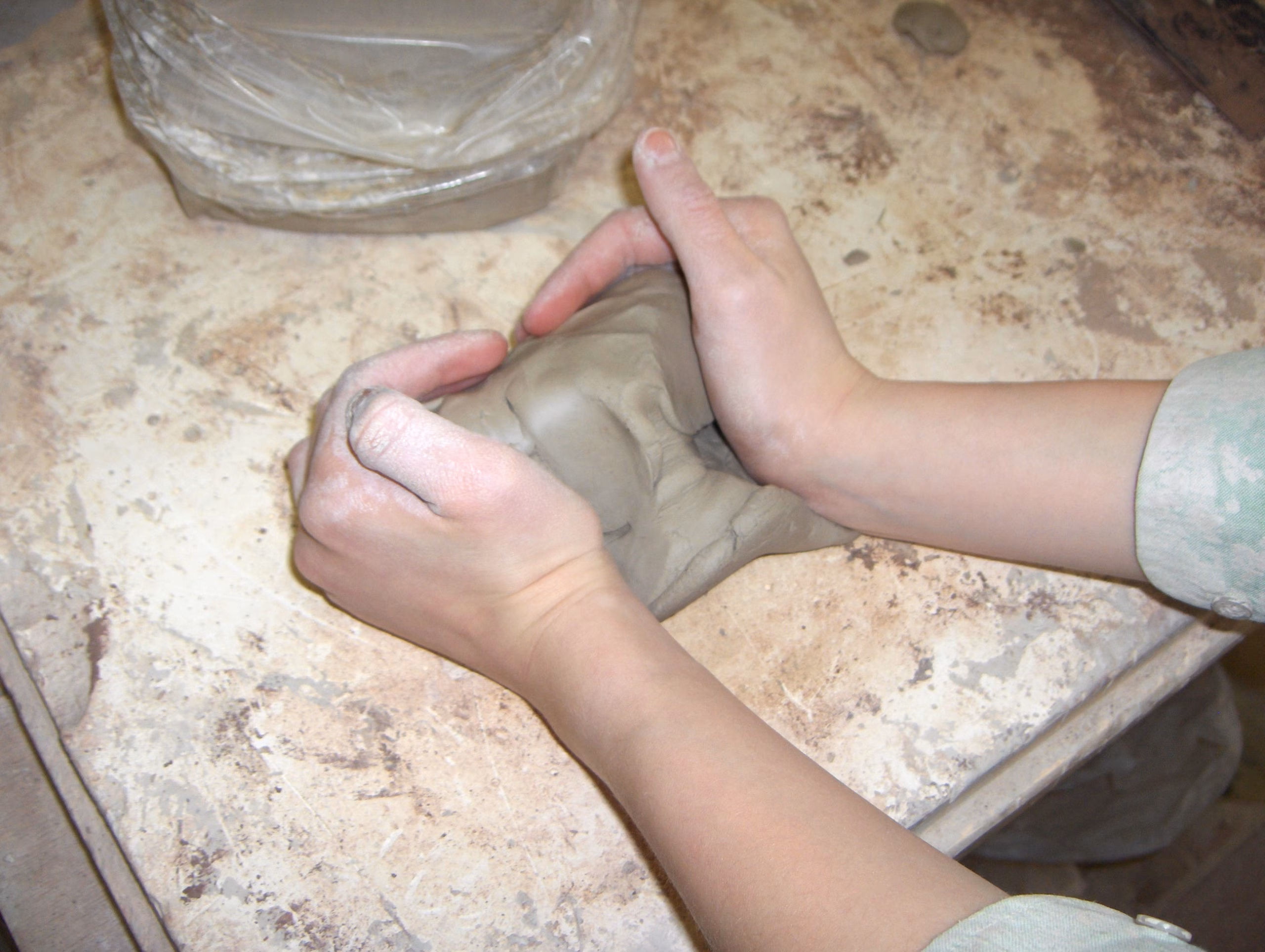 Guida Completa alle Argille da Modellare: Terracotta, Terraglia, Refrattaria, Gres e Porcellana a Confronto 7 Mani di un ceramista che impastano e compattano un panetto di argilla fresca per eliminare bolle d aria ed omogeneizzare la plasticità